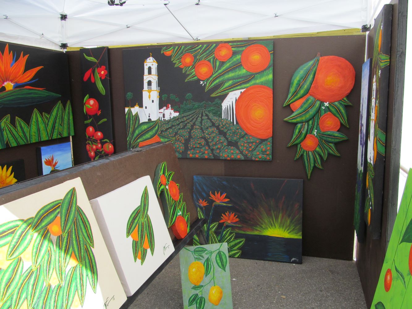 Booth full of orange paintings by Guy Wann